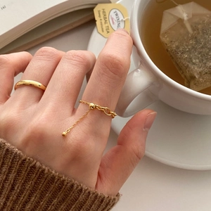 Detailed view of 925 sterling silver chain ring with a gold bead on a hand