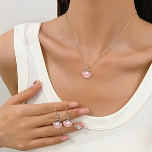 Fashionable pink shell pearl jewelry set featuring a necklace and earrings on a model