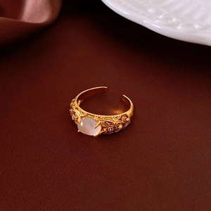 Détail macro d'une bague dorée avec pierre ovale et motifs filigranes ciselés