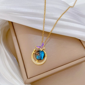 Golden necklace featuring a crescent moon and purple butterfly pendant with starry stone
