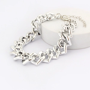 Close-up of polished silver heart link chain pet necklace on a white cylindrical stand