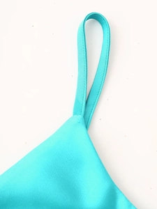 Détail des coutures sur la bretelle en satin d'une robe moulante bleu sarcelle