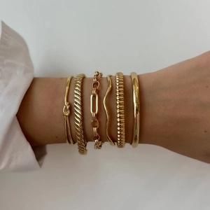 Vue détaillée de six bracelets en acier inoxydable plaqué or 18k aux styles texturés