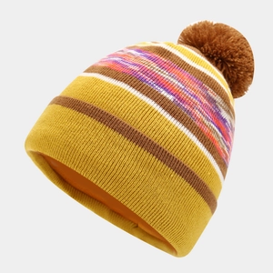 Close-up of ginger yellow striped knit hat with a fluffy brown pom-pom and thick texture