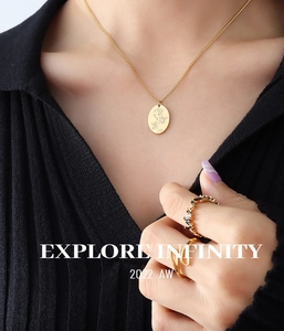 Dettaglio della collana con pendente rosa vintage oro e anello con gemma nera su modella