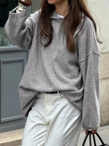 Close-up of a casual grey hooded knit sweater featuring a stylish relaxed fit and long sleeves