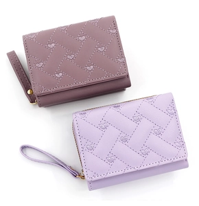Detail of short tri-fold wallets featuring heart embroidery and diamond quilted faux leather
