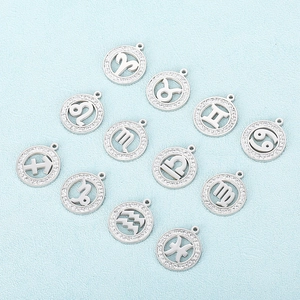 Set of 12 hollowed silver zodiac charms with sparkling crystal insets on blue surface