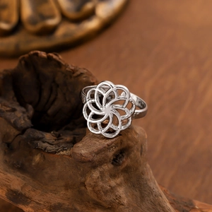 Minimalist silver multi-layer hollow geometric ring on a rustic dark wood background