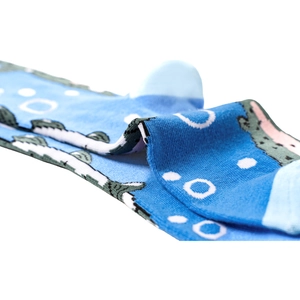 Close-up of blue knitted cotton sock with green serrated edges and white polka dots