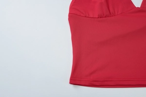 Vue détaillée de la double couture et de la maille de ce haut rouge ajusté avec col en v