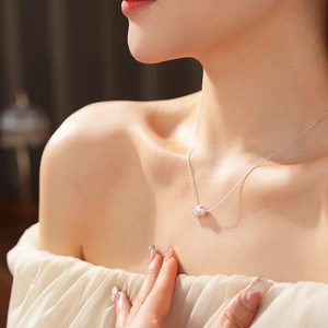 Gros plan d'un collier en argent avec perle et zircon porté sur le cou d'un mannequin