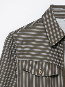Detailed close-up of brown striped poplin shirt with front pocket and neat stitching