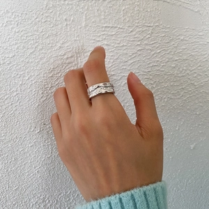 Detailed close-up of an irregular liquid texture silver ring with a 925 sterling finish