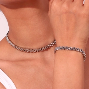Detail of silver Jubilee style stainless steel necklace and bracelet set on a model
