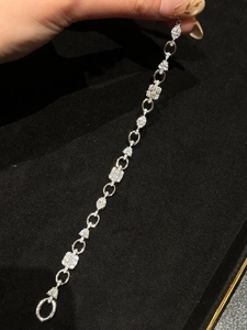 Macro detail of silver geometric bracelet with white zircon pave setting on black velvet