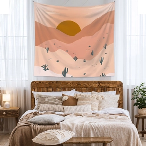 Detail of bohemian tapestry featuring abstract sunset and cactus over a cozy bed
