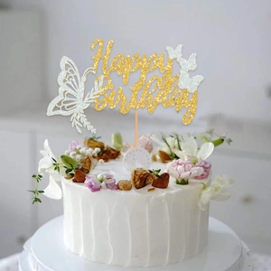 Sparkling gold and silver Happy Birthday cake topper with butterflies on white cake