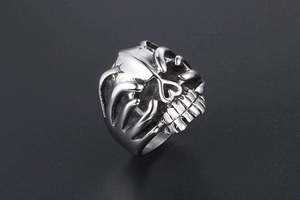 Macro side view of silver punk skull ring showing detailed stainless steel textures