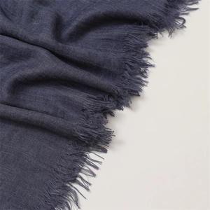 Close-up of navy blue linen scarf fabric texture with delicate fringe edge detail
