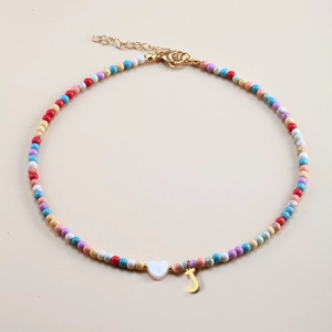 Detailed view of colorful beaded necklace with white heart and gold J letter pendant