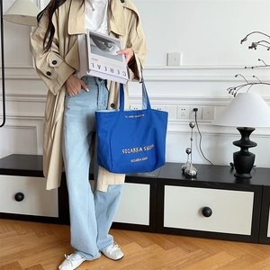 Detail der Klein-blauen Canvas-Tasche mit gelber Stickerei und großem Fassungsvermögen