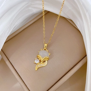 Detailed shot of golden fox necklace with cat eye stone and zircon on silk