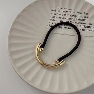 Close-up of black high-elastic hair tie with a polished gold-plated alloy curved clip