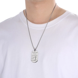 Detail of silver dog tag pendant necklace with emotional engraving worn by a male model