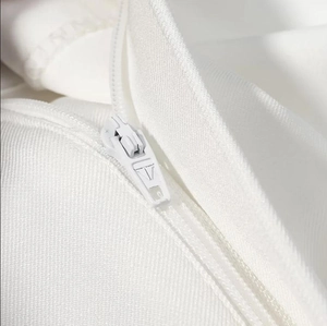 Détail de la fermeture éclair invisible et du tissu sergé blanc sur l'ensemble femme
