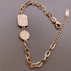 Macro detail of rose gold link chain bracelet with lucky angel and rabbit pendants