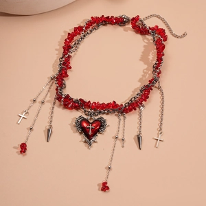 Detailed macro view of Gothic red heart pendant and cross charms on beaded necklace