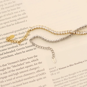 Detailed macro view of gold and silver square-cut tennis bracelets on book pages