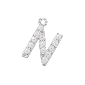 Detailed view of silver letter N pendant featuring elegant white pearls on metal surface