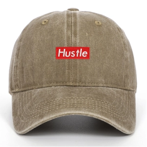 Detail of Hustle embroidery patch on khaki washed cotton vintage baseball cap