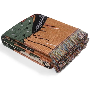 Detail view of woven bohemian blanket showing colorful fringes and intricate jacquard texture
