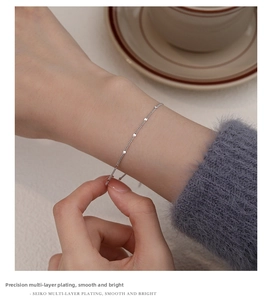 Close-up of minimalist S925 sterling silver chain bracelet with shiny round sequin charms