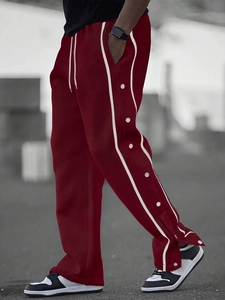 Detail view of burgundy men's joggers with white side stripes and snap button closures