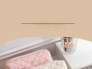Detail of quilted bunny pencil case with pink and beige rhombic patterns and soft fabric texture