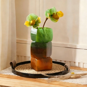 Close-up of three-tier geometric resin vase with marble texture and floral decor
