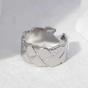 Polished silver stainless steel open ring with woven texture on white background