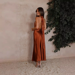 Detail view of the rust red satin maxi dress featuring a halter neck and long back ribbons