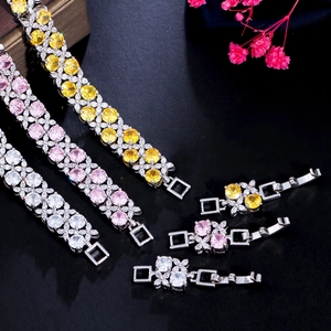Detailed macro shot of three zircon bracelets in yellow, pink and white with folding clasps