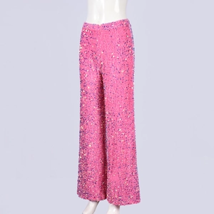 Détail macro de paillettes rose vif sur le pantalon large élégant à taille haute