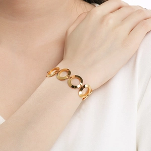 Detailed close-up of 18K gold plated stainless steel interlocking ring bracelet on wrist