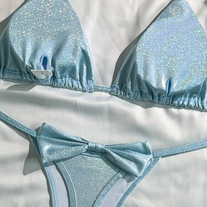 Detail of light blue sequined bikini fabric with shimmering texture and tie-side bow