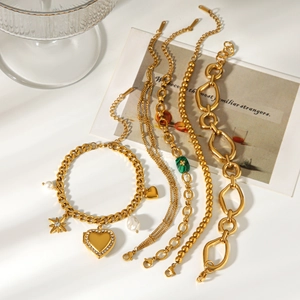 Detail view of 18k gold stainless steel bracelet stack with malachite and pearl charms