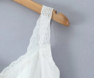 Détail des bretelles en dentelle blanche et de la texture rayée du haut pour femme