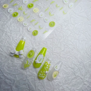 Detail of lily of the valley nail stickers with floral patterns on almond press-on nails