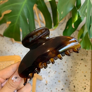 Detailed close-up of large amber brown resin hair claw clip with glossy finish
